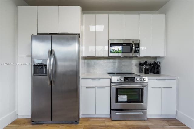 1114 SW 11th Ave, Miami, FL 33129 - kitchen with stainless steel appliances, light countertops, white cabinetry, and backsplash
