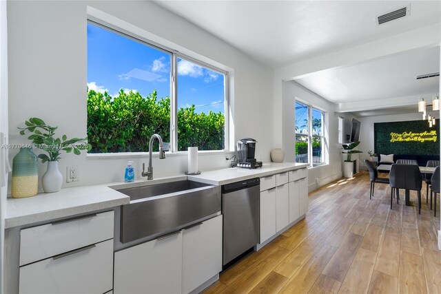 1114 SW 11th Ave, Miami, FL 33129 - kitchen with stainless steel dishwasher, white cabinetry, light countertops, and light wood-style floors