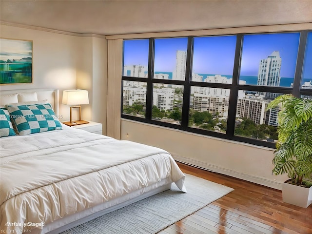bedroom with baseboards, a view of city, and hardwood / wood-style flooring