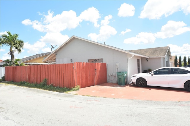 view of property exterior featuring stucco siding and fence