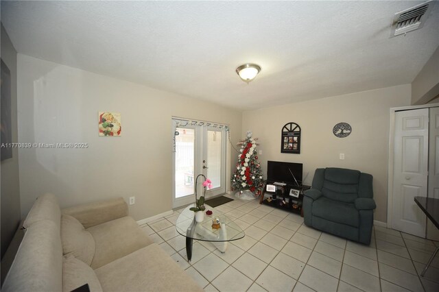 living room featuring baseboards, visible vents, french doors, and light tile patterned floors