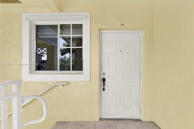 view of exterior entry featuring stucco siding