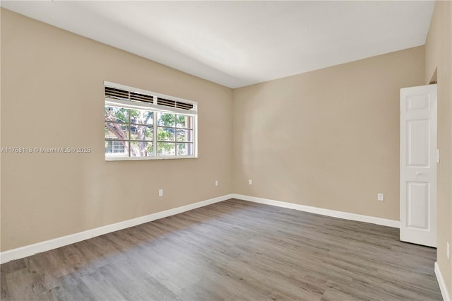 empty room with baseboards and wood finished floors