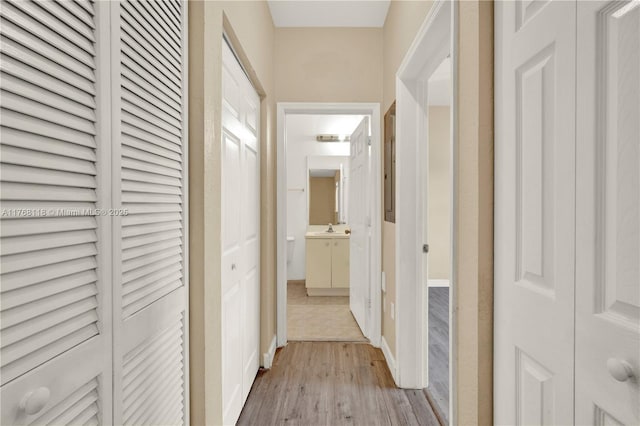 hall with a sink and wood finished floors
