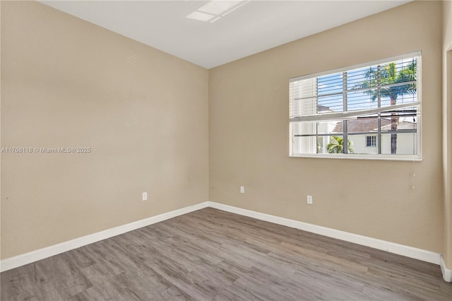 empty room featuring baseboards and wood finished floors