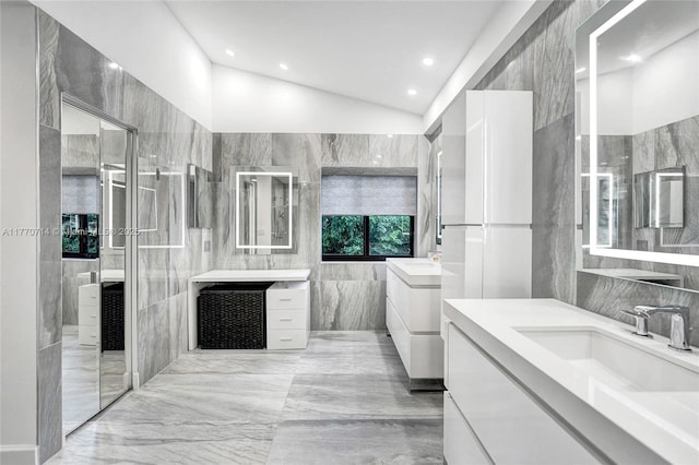 2649 Nelson Ct, Weston, FL 33332 - bathroom featuring tile walls, two vanities, vaulted ceiling, marble tiled floors, and recessed lighting