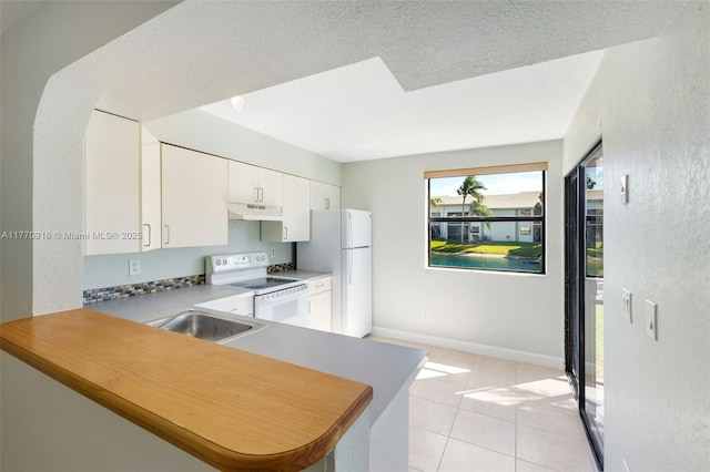1111 Adams Ave Unit 1111B, Homestead, FL 33034 - kitchen with white cabinetry, white appliances, light tile patterned floors, under cabinet range hood, and a sink