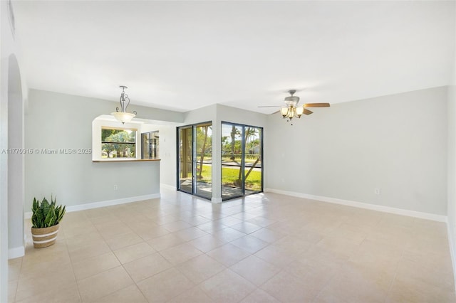1111 Adams Ave Unit 1111B, Homestead, FL 33034 - empty room with a ceiling fan, light tile patterned flooring, arched walkways, and baseboards