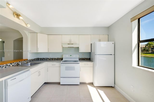 1111 Adams Ave Unit 1111B, Homestead, FL 33034 - kitchen featuring a sink, under cabinet range hood, light tile patterned floors, white appliances, and white cabinets