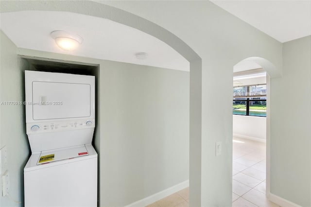 1111 Adams Ave Unit 1111B, Homestead, FL 33034 - laundry area featuring stacked washer / drying machine, baseboards, light tile patterned flooring, arched walkways, and laundry area