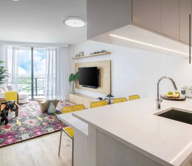 living area featuring floor to ceiling windows, light wood-style floors, and a tiled fireplace
