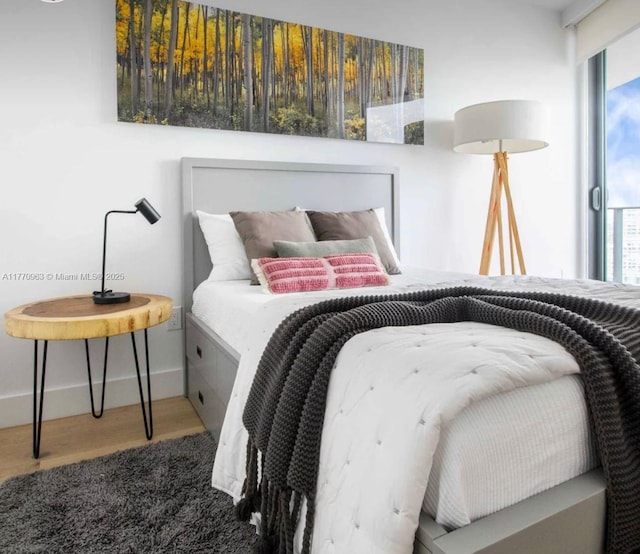 bedroom with baseboards and wood finished floors