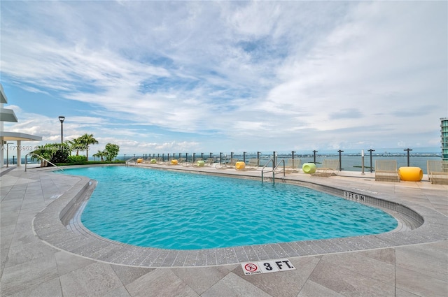 community pool with fence and a patio