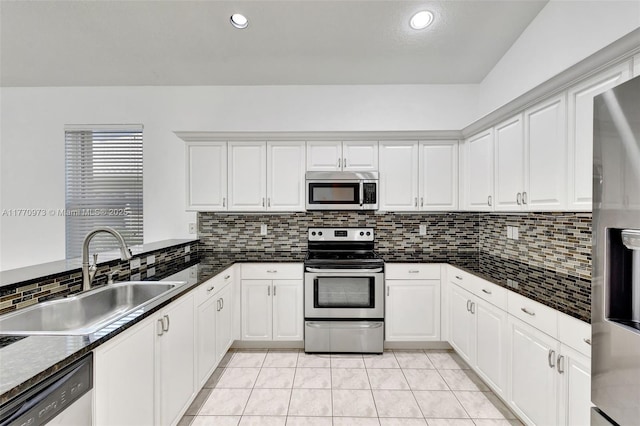 kitchen featuring a sink, decorative backsplash, appliances with stainless steel finishes, and dark countertops