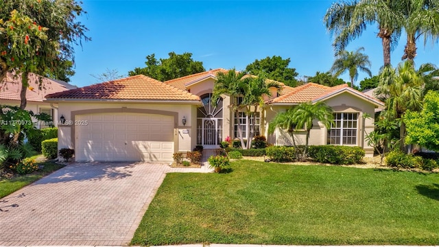 mediterranean / spanish-style house featuring a garage, stucco siding, a front lawn, and a tile roof