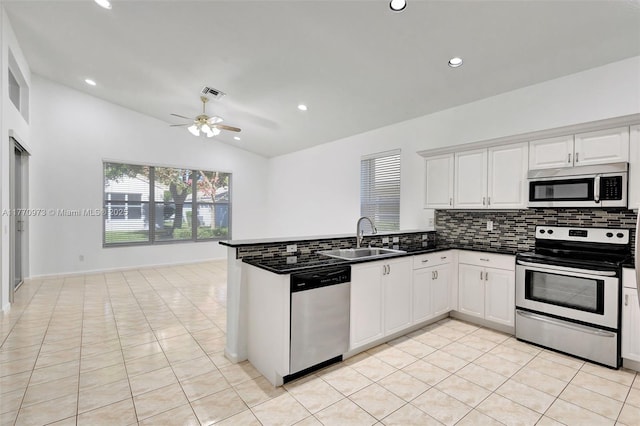 kitchen featuring decorative backsplash, a sink, a peninsula, lofted ceiling, and stainless steel appliances