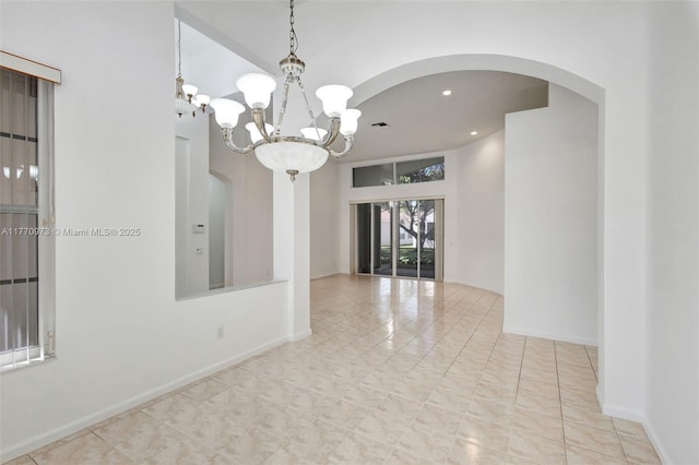 empty room featuring visible vents, baseboards, recessed lighting, a chandelier, and arched walkways