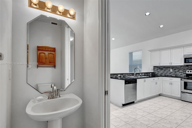 bathroom featuring a sink, backsplash, and recessed lighting