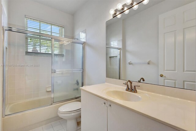 bathroom with toilet, tile patterned floors, bath / shower combo with glass door, and vanity