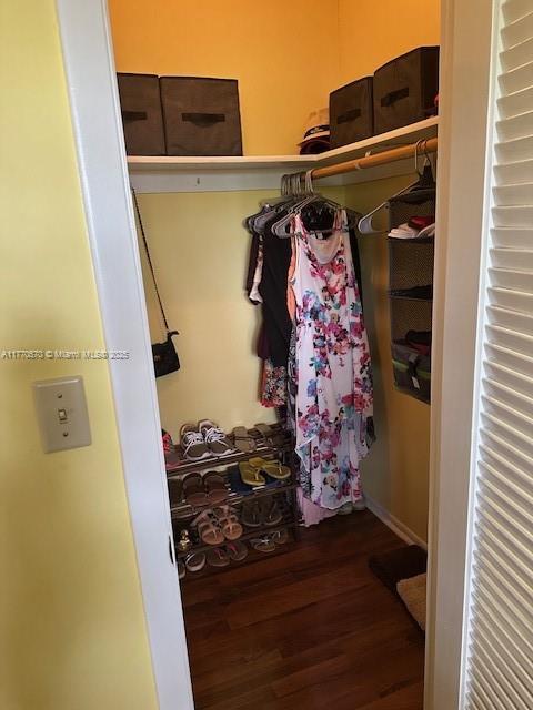 walk in closet with wood finished floors