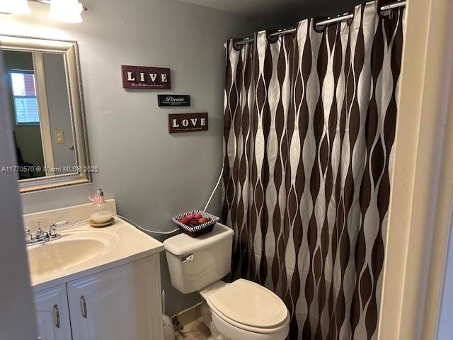 full bathroom featuring toilet, vanity, and a shower with shower curtain