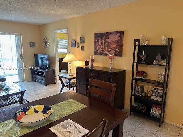 dining area with light tile patterned floors and a textured ceiling