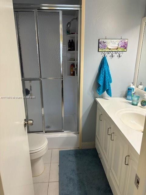 full bathroom featuring toilet, a stall shower, tile patterned flooring, and vanity
