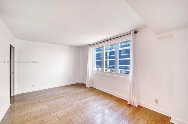 unfurnished room featuring baseboards and wood finished floors
