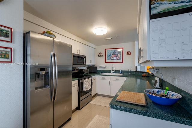 10140 W Bay Harbor Dr Unit 502B, Bay Harbor Islands, FL 33154 - kitchen featuring appliances with stainless steel finishes, white cabinets, and dark countertops