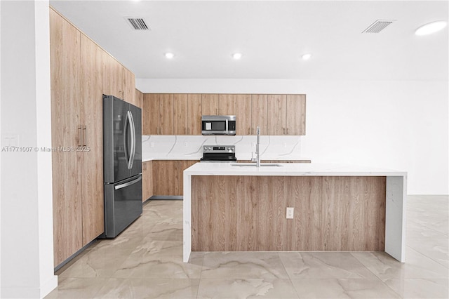 kitchen featuring light countertops, marble finish floor, modern cabinets, and appliances with stainless steel finishes