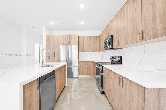 kitchen featuring modern cabinets, a sink, stainless steel appliances, and light brown cabinetry