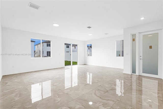 empty room with marble finish floor, recessed lighting, baseboards, and visible vents