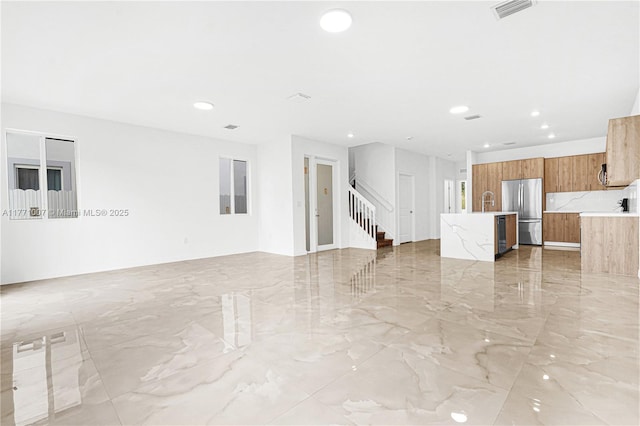 unfurnished living room featuring marble finish floor, visible vents, recessed lighting, and stairway