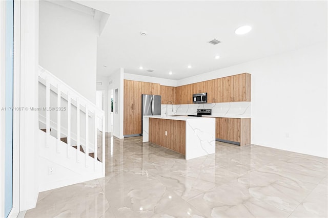 kitchen featuring marble finish floor, visible vents, modern cabinets, appliances with stainless steel finishes, and brown cabinetry