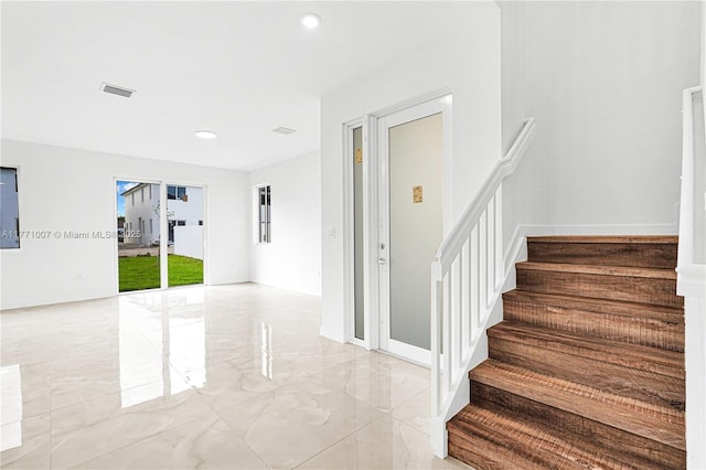 stairway featuring marble finish floor, recessed lighting, and visible vents