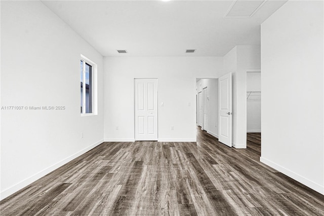 unfurnished bedroom featuring dark wood-type flooring, baseboards, and visible vents