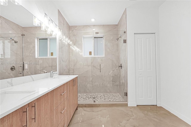 full bathroom with a shower stall, baseboards, double vanity, marble finish floor, and a sink