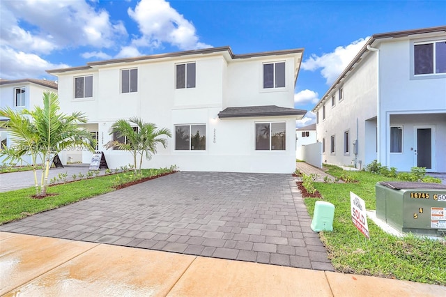 view of front of property featuring decorative driveway and stucco siding