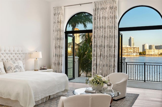 3918 Island Estates Dr, Aventura, FL 33160 - bedroom with wood finished floors, a view of city, access to exterior, and a water view
