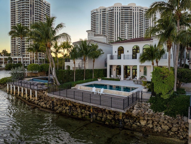 3918 Island Estates Dr, Aventura, FL 33160 - rear view of house featuring a water view, a patio area, fence, a balcony, and an outdoor pool