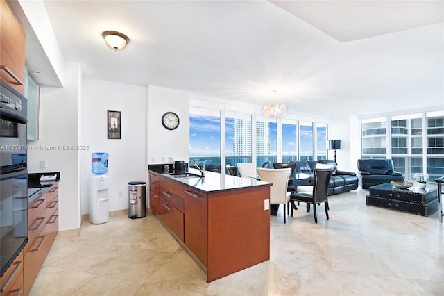 1830 S Ocean Dr Unit 2808, Hallandale Beach, FL 33009 - kitchen with dark countertops, a chandelier, brown cabinets, a peninsula, and modern cabinets