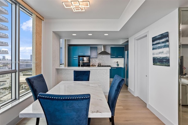 dining room featuring baseboards, recessed lighting, and light wood-type flooring
