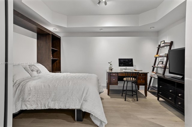 bedroom featuring a tray ceiling and wood finished floors