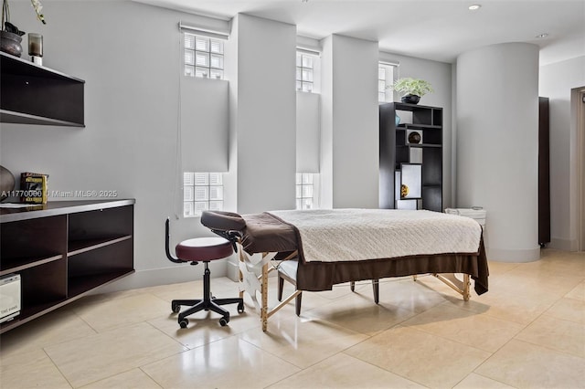 bedroom with baseboards and light tile patterned floors