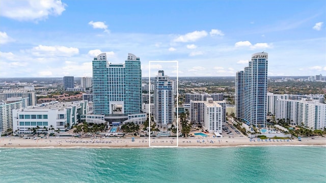 exterior space featuring a view of the beach, a water view, and a view of city