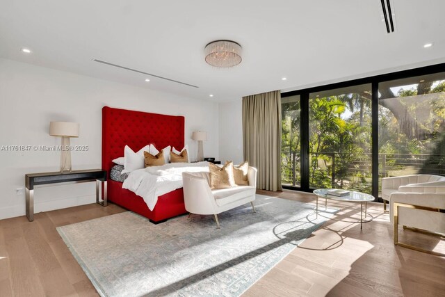3232 Emathla St, Miami, FL 33133 - bedroom with wood finished floors, floor to ceiling windows, and recessed lighting