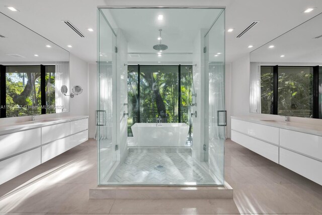 3232 Emathla St, Miami, FL 33133 - bathroom featuring a shower stall, two vanities, tile patterned flooring, a freestanding bath, and recessed lighting