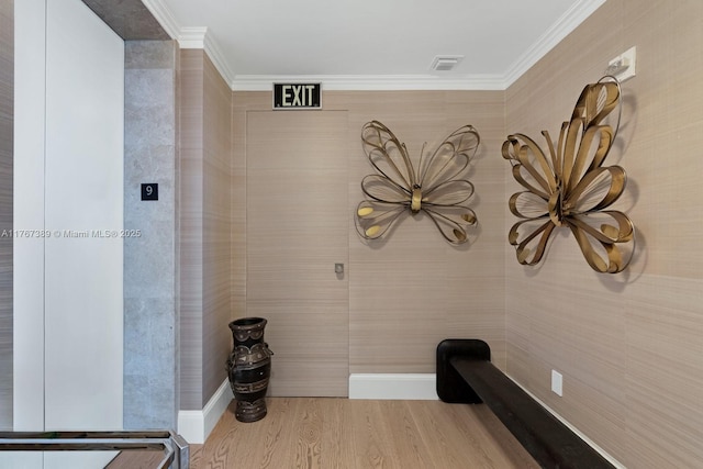 interior space featuring visible vents, ornamental molding, and wood finished floors