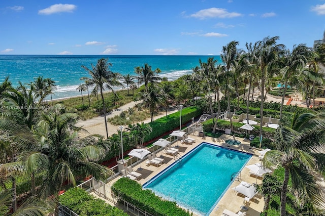 pool featuring a water view and a patio area