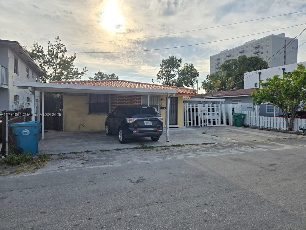 791 NW 22nd Pl, Miami, FL 33125 - view of front of home featuring a tile roof, driveway, and fence